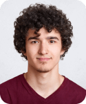 Person with curly hair and maroon shirt smiling.