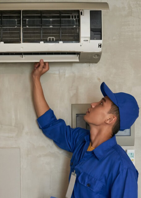 Technician inspecting air conditioning unit